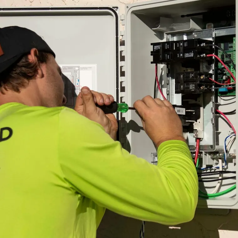 Técnico trabajando con un destornillador en una caja de control eléctrico