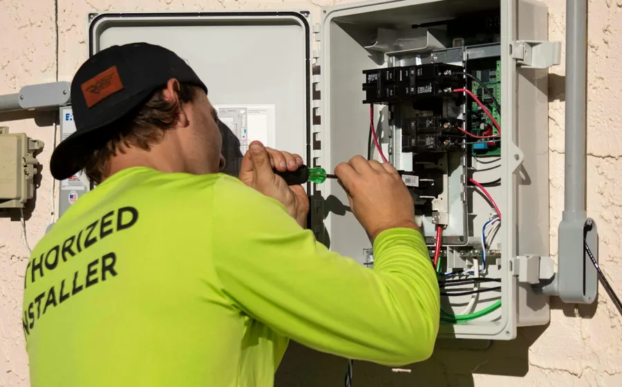 Técnico trabajando con un destornillador en una caja de control eléctrico