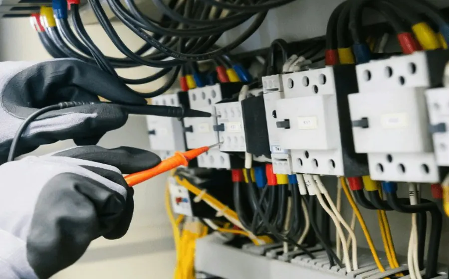 Técnico midiendo con un tester los contactos de un tablero eléctrico